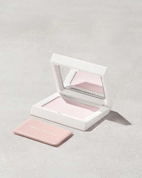 Open compact of the Invisimatte Setting Powder and sponge on a light background.